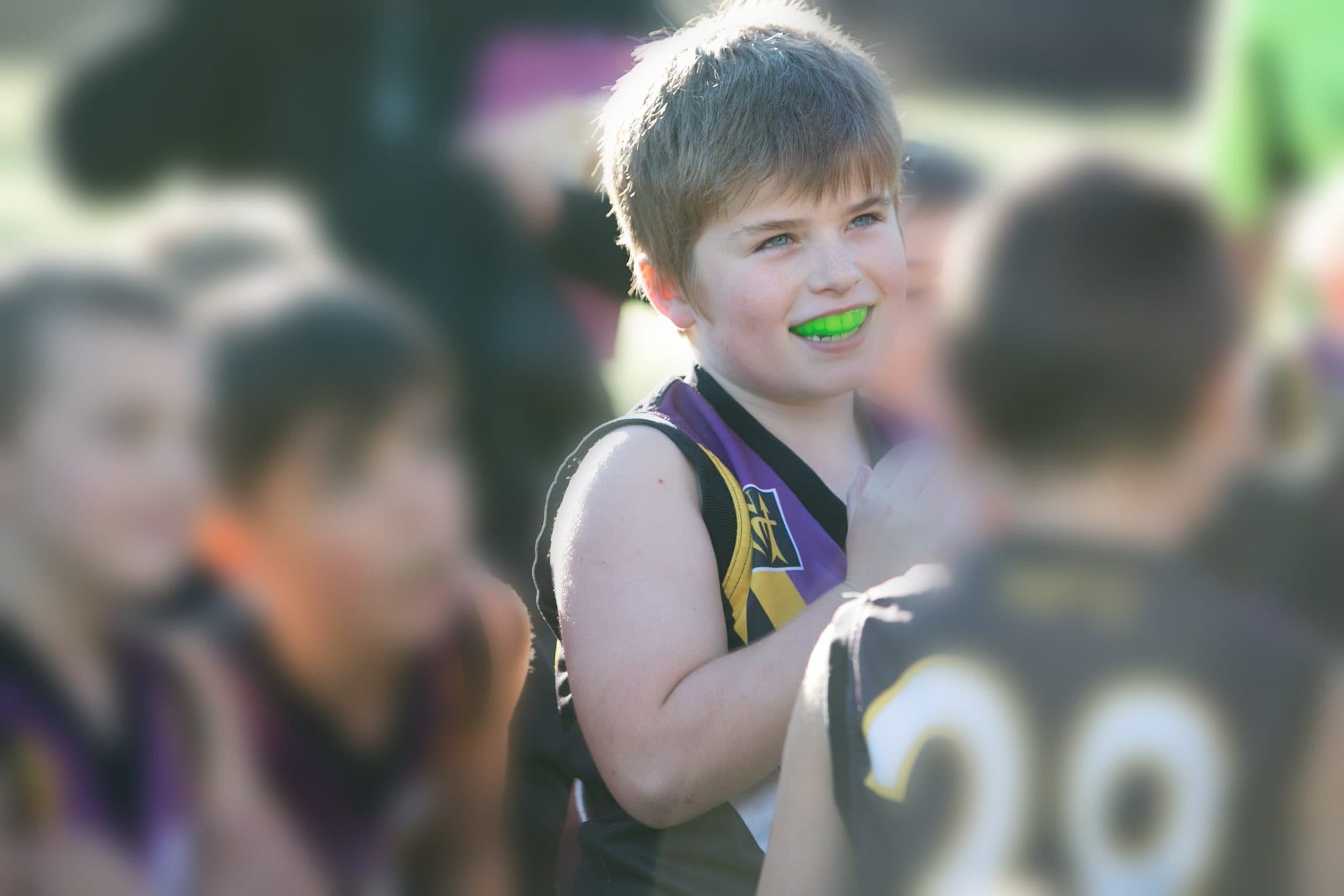 A junior footballer wearing a mouthguard during a game